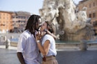 A beautiful mixed-race couple embrace in Piazza Navona in Rome, Italy